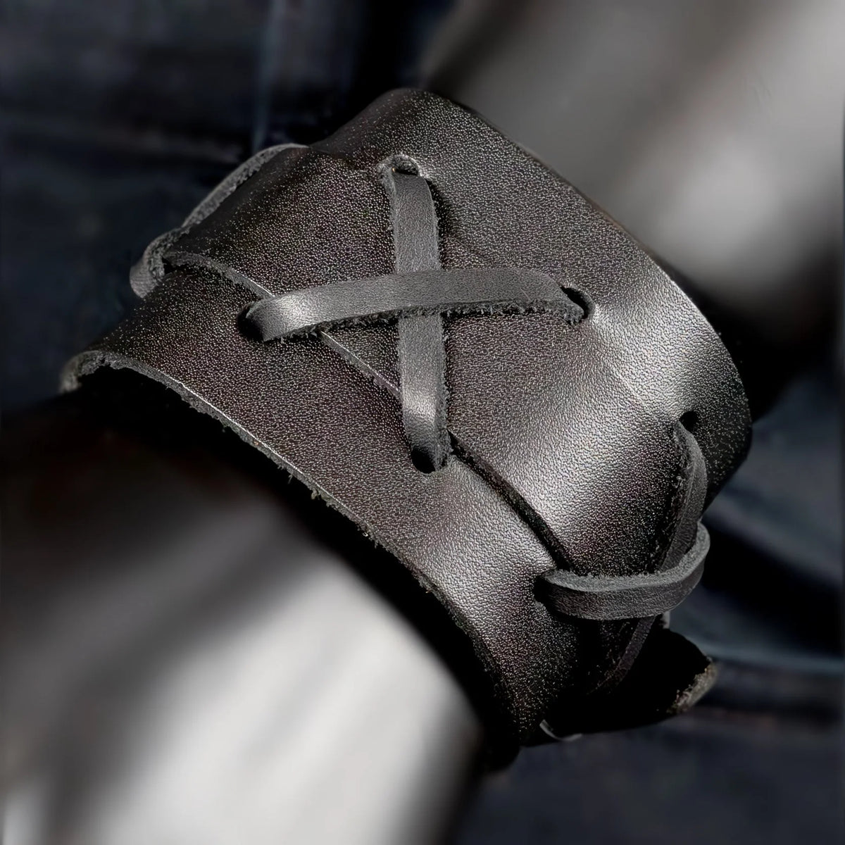 Leather cuff bracelet with criss-cross lacing detail.