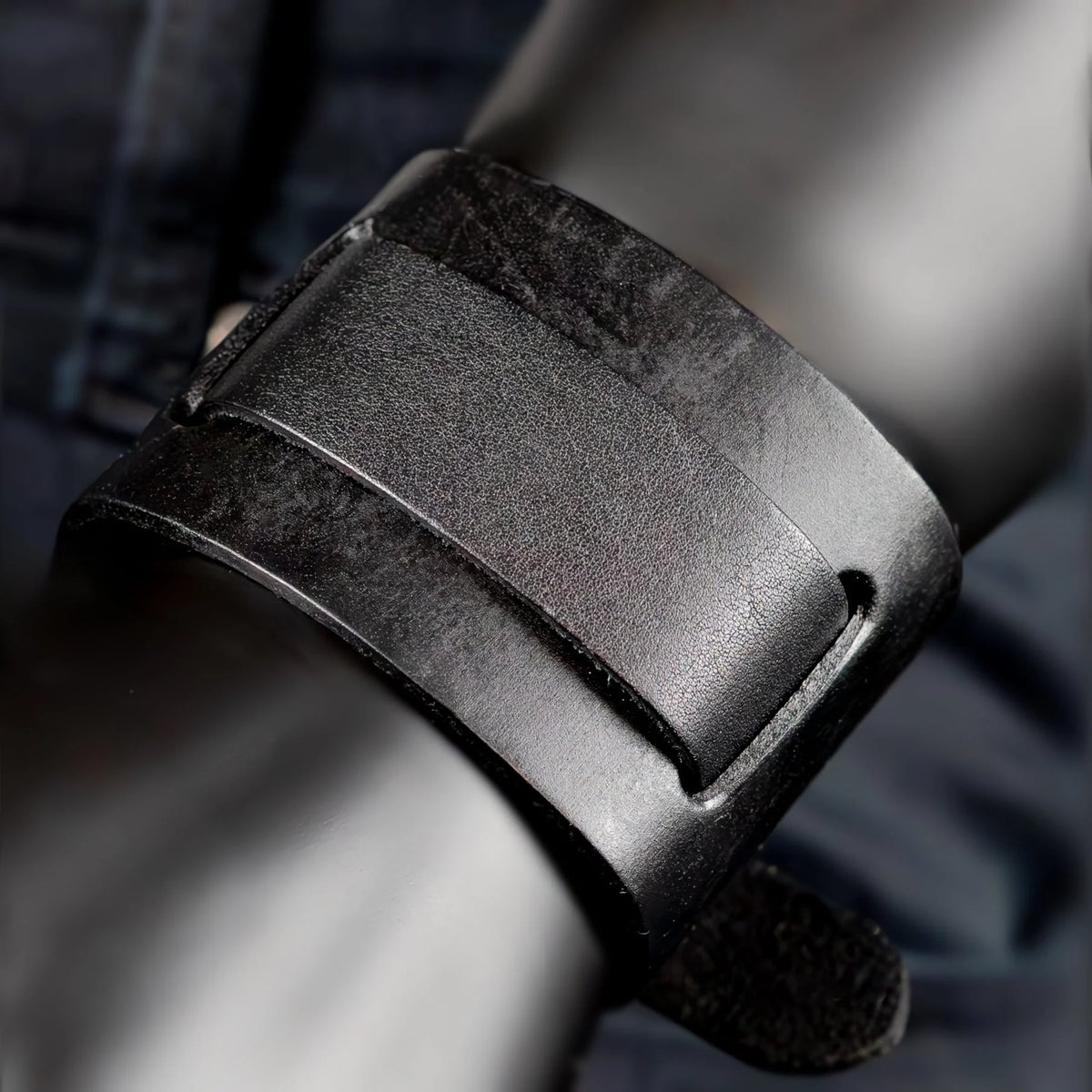 Black leather watch strap or band with a buckle.