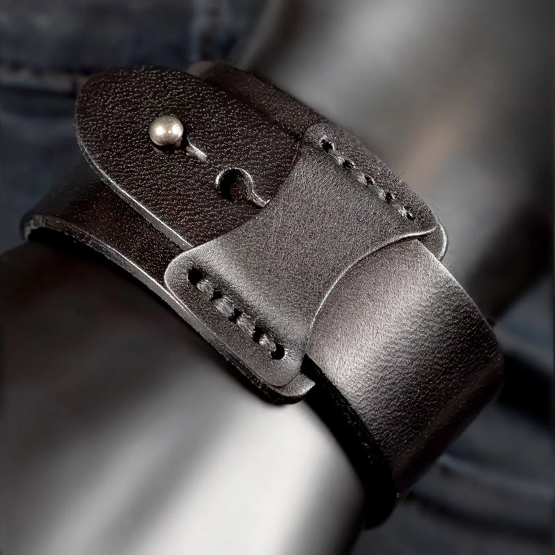 Leather watch strap with a metal stud and hook closure.