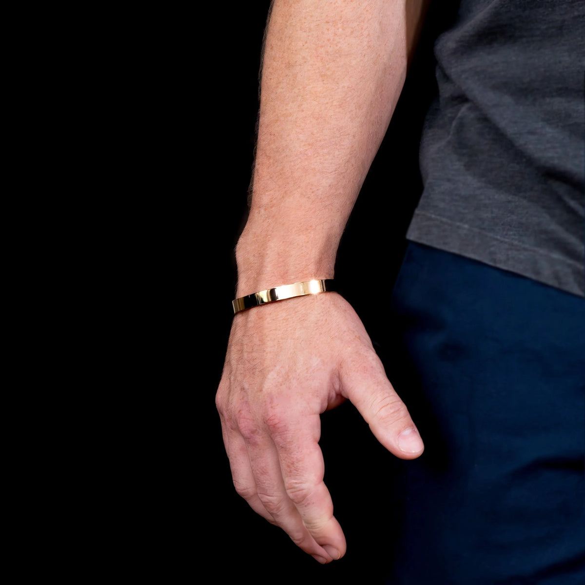 Gold and black bracelet worn on a wrist.