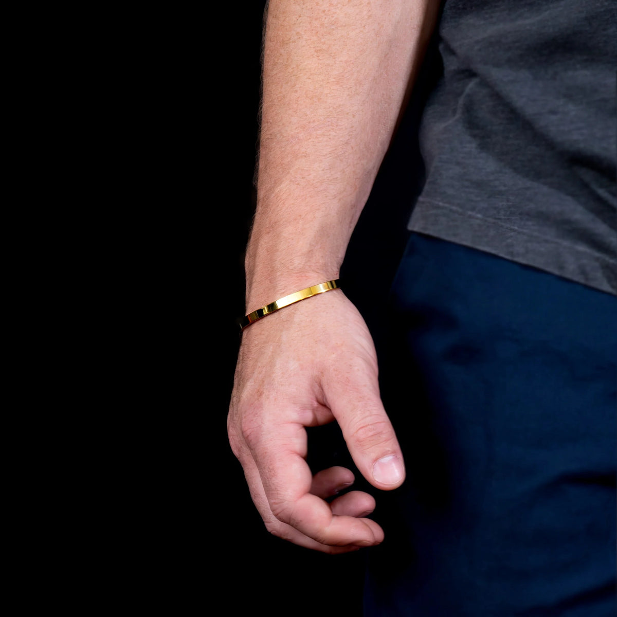 Gold bracelet worn on a wrist.