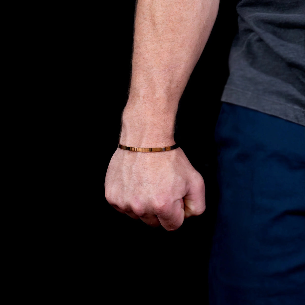 Gold bracelet worn on a wrist.