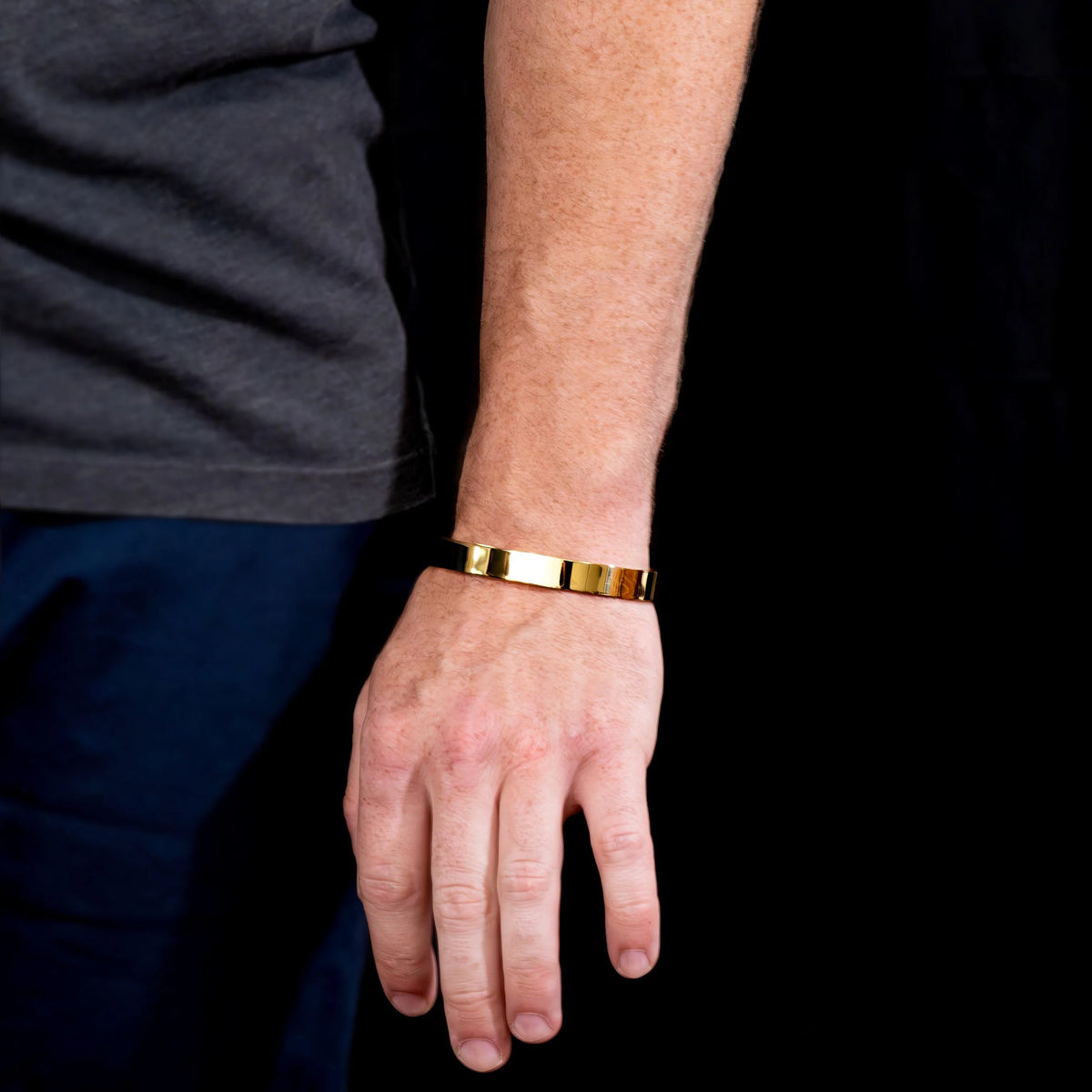 Gold metallic bracelet worn on a wrist.