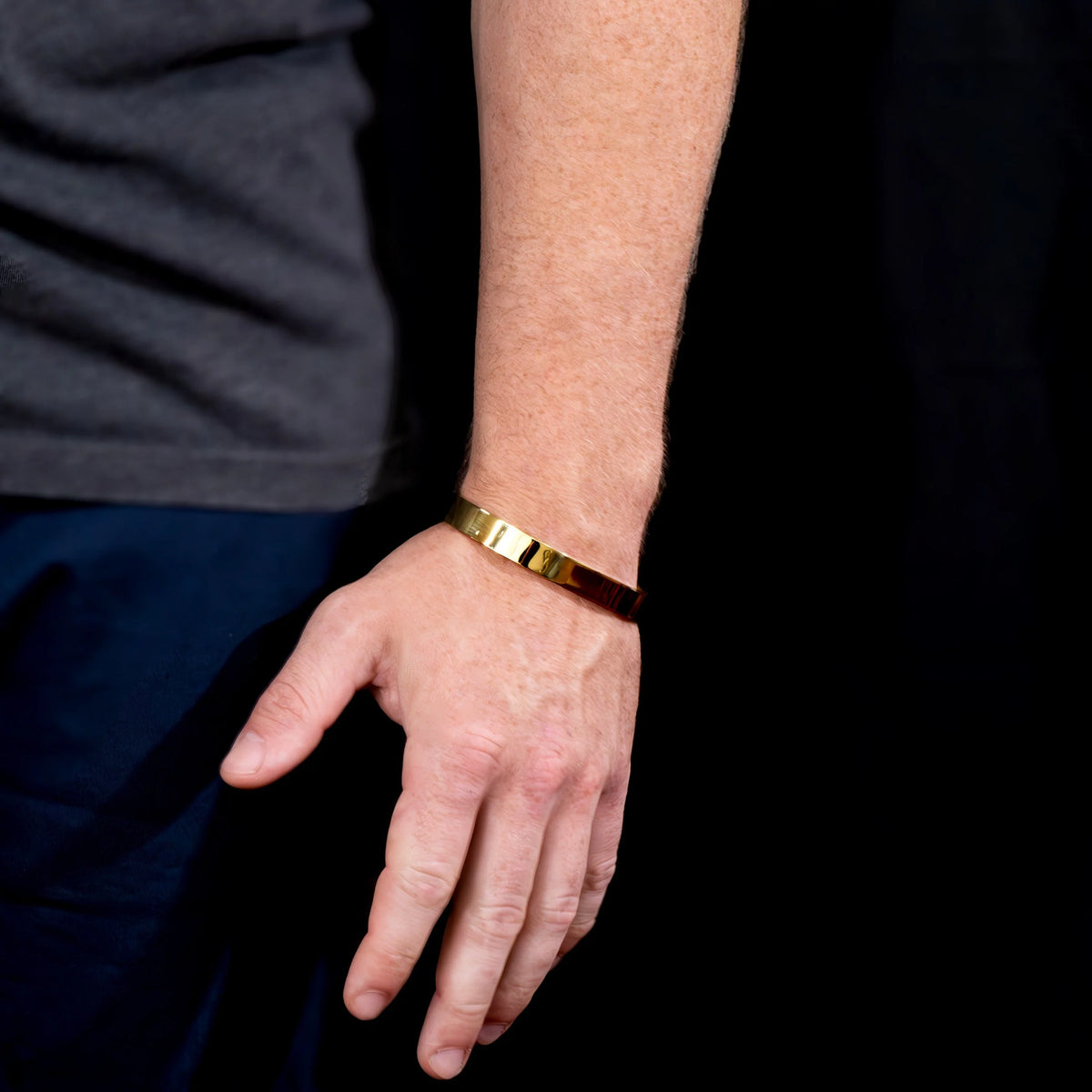 Gold metallic bracelet worn on a wrist.