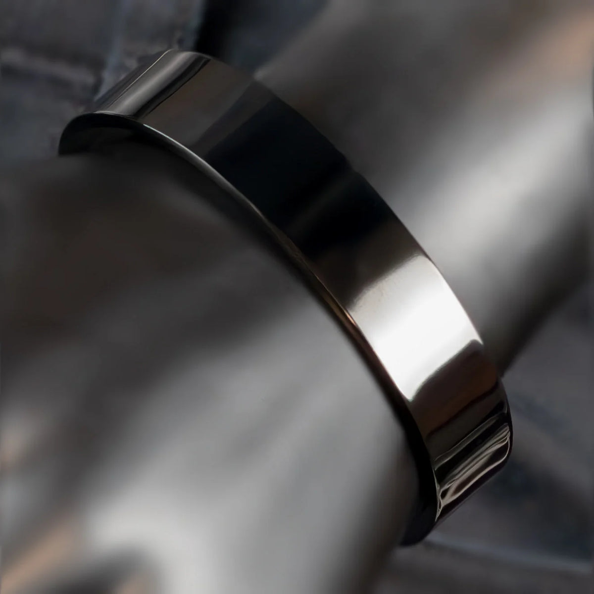 Sleek, metallic bracelet or wristband with a smooth, curved surface.