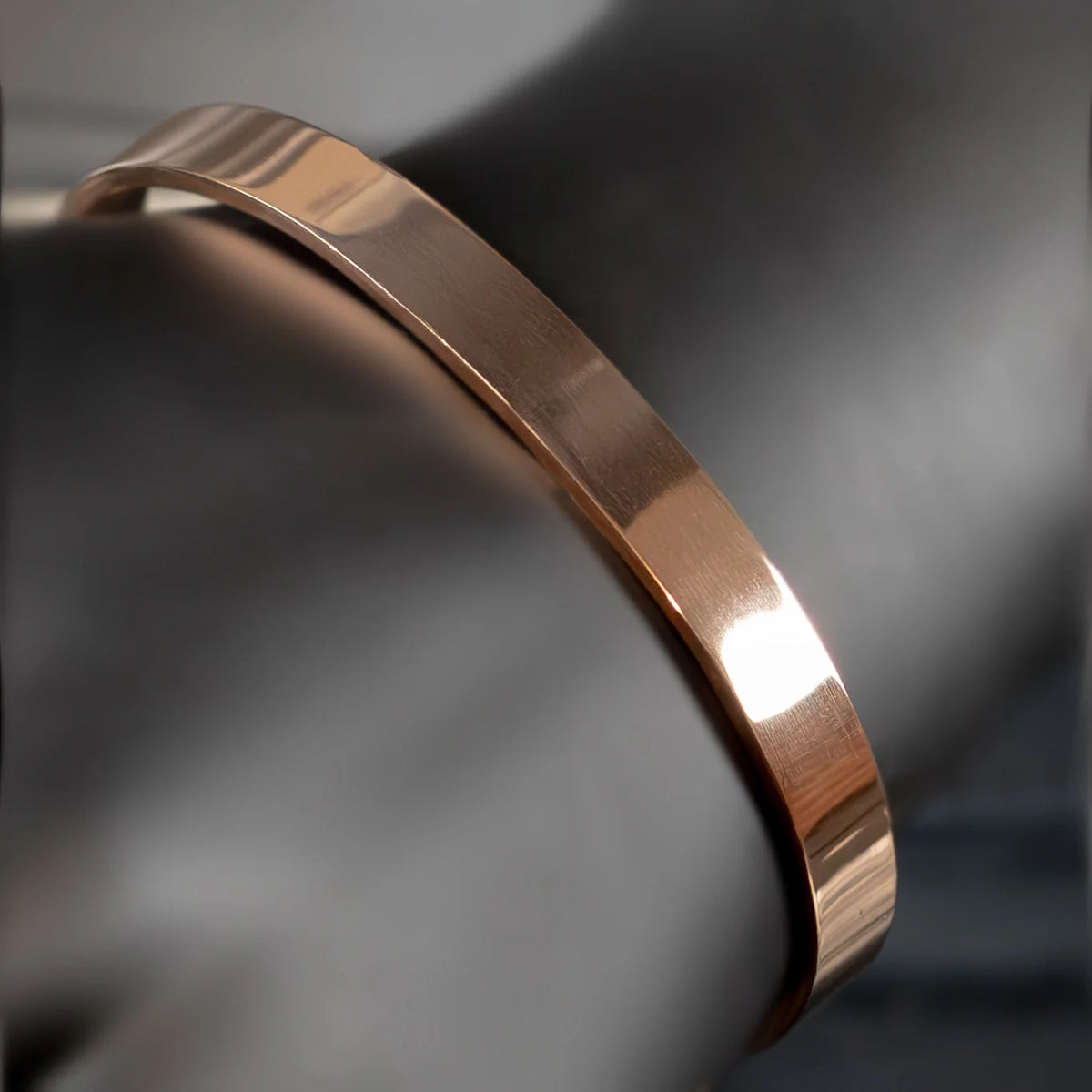 Sleek rose gold metal bracelet or bangle with a polished finish.