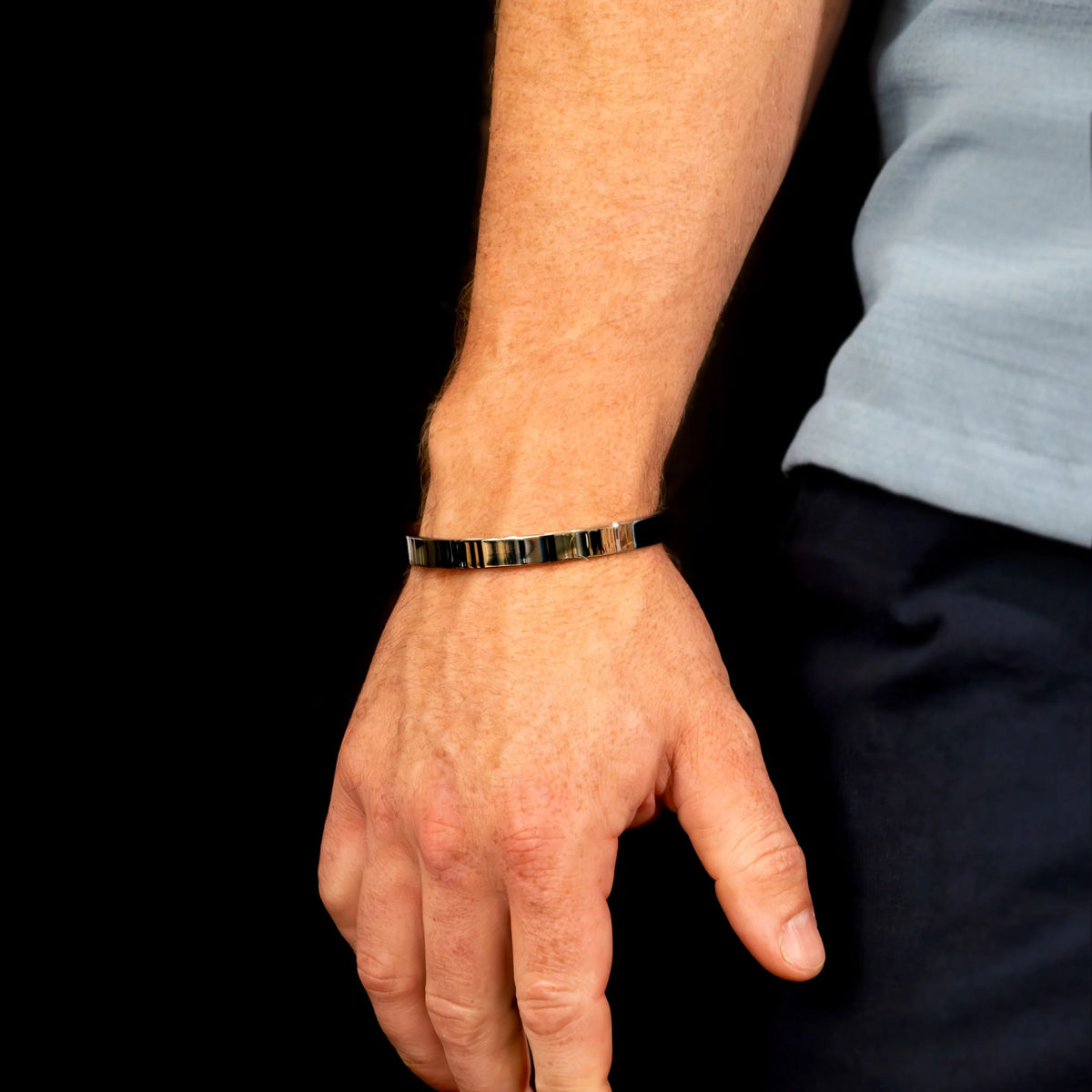 Gold and black striped bracelet worn on a wrist.