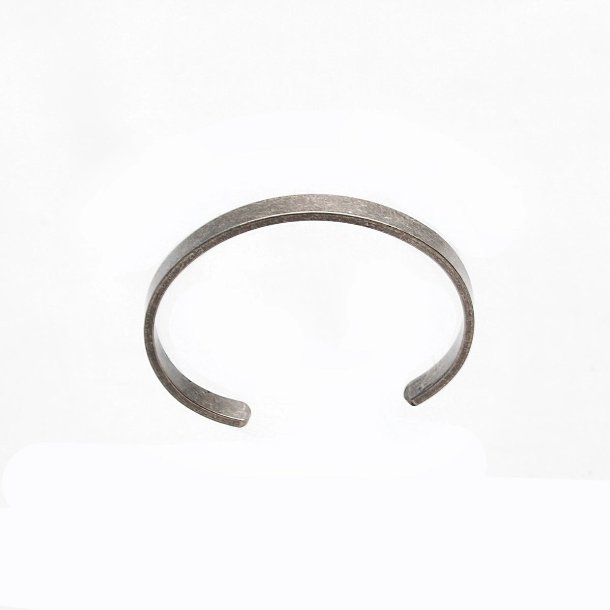 Simple silver metal cuff bracelet with open ends.