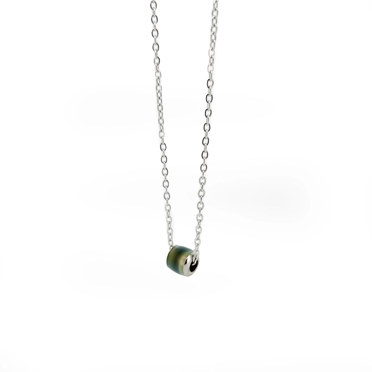 Silver necklace with a small green bead pendant.