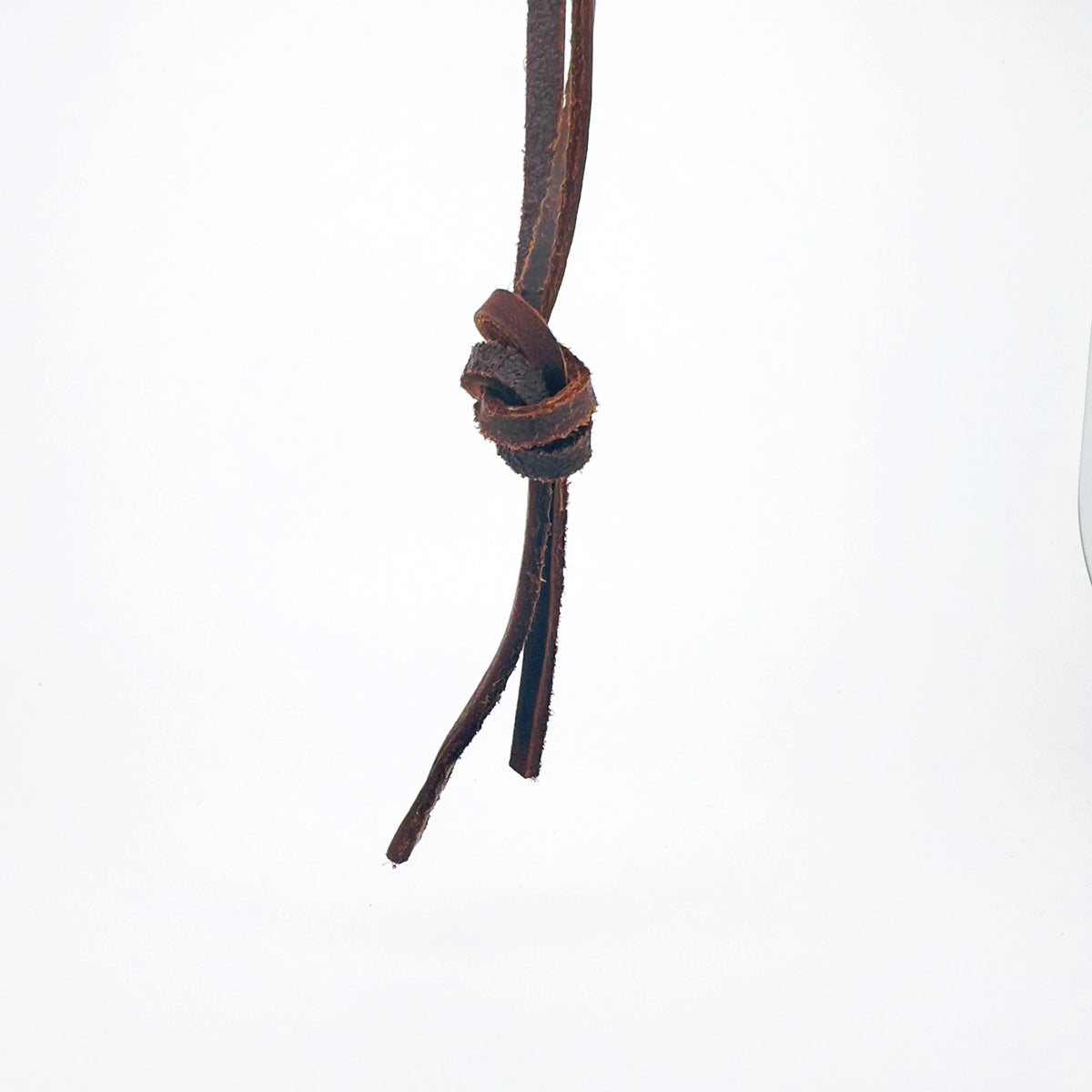 Brown leather cord tied in a knot with loose ends hanging down.