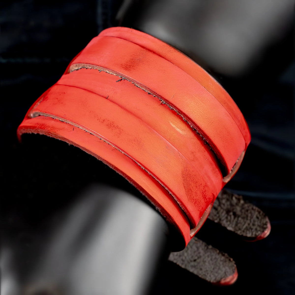 Red leather cuff bracelet with multiple bands and a dark clasp.