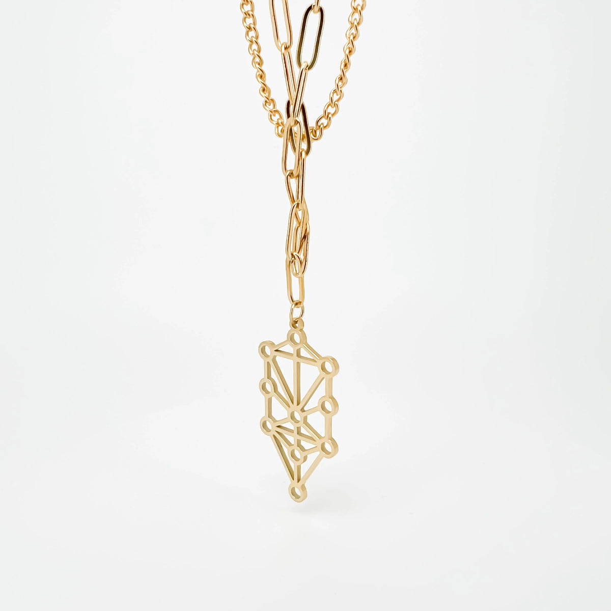 Gold pendant necklace featuring a geometric tree of life design.