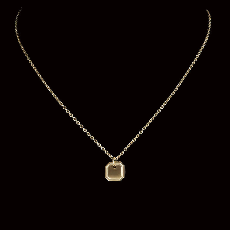 Gold necklace with a square pendant.