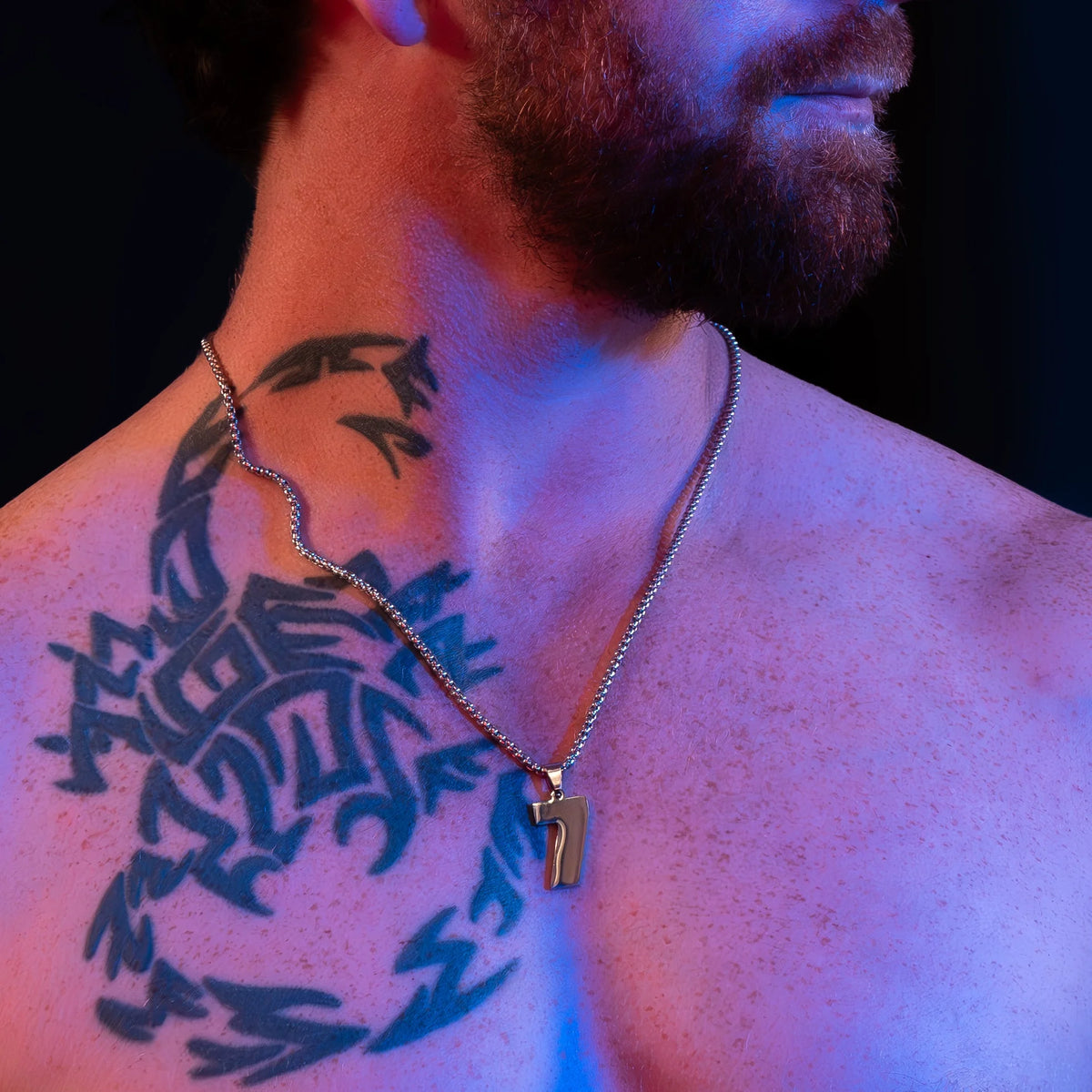 Tribal-style tattoo on a person’s upper chest and neck area.